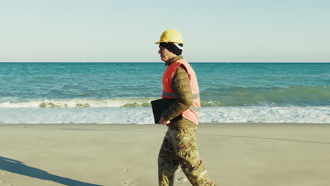 elderly engineer reaching his worksite by walking along the beach