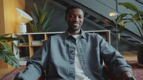portrait of young african american businessman sitting in office armchair