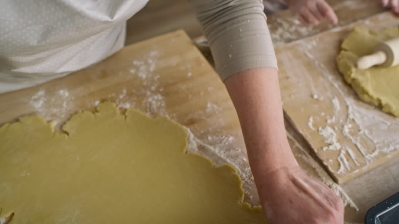 Top view of senior woman and child rolling dough