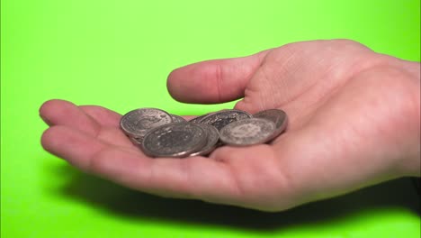 Swiss-Franc-Coins,-Currency-in-Switzerland,-In-Hand-with-Green-Screen,-Stop-Motion