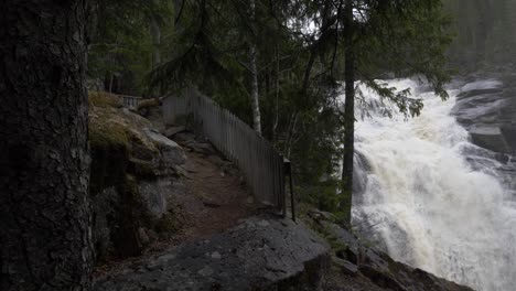 Großer-Wasserfall-Und-Ein-Mädchen,-Das-Daneben-Geht