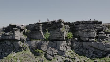 climbers on top of gritstone rocks bamford edge in hope valley, england, uk