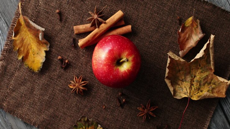 Ripe apple with fallen leaves and spices