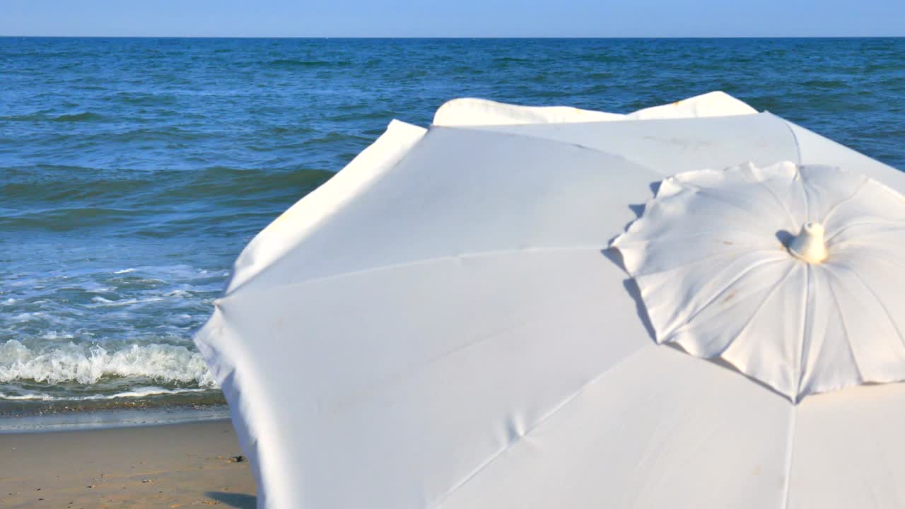 색 해변 우산과 은 날의 파란 바다.