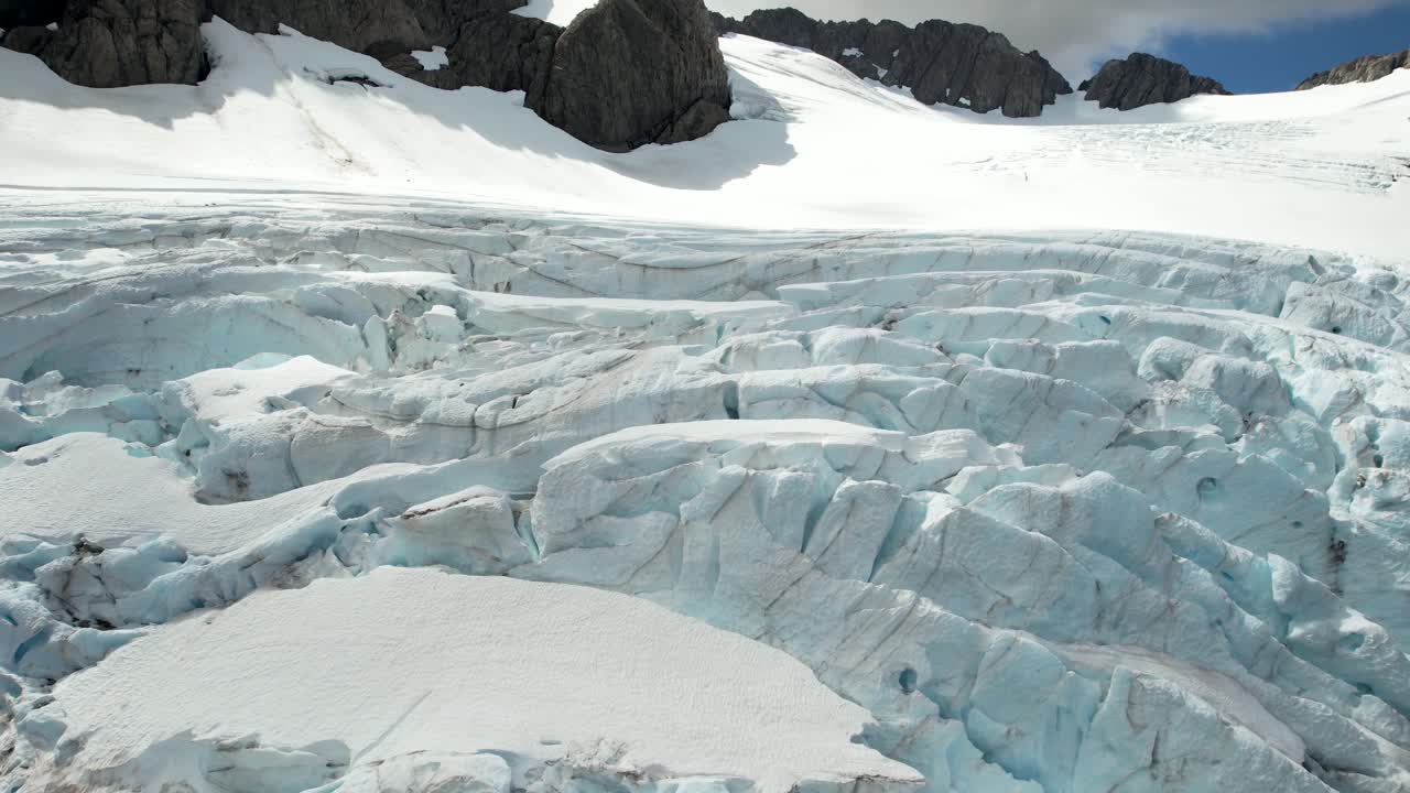 destacado primer plano aéreo de glaciar helado y nieve en la cima de la montaña