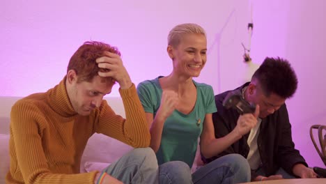 friends playing video games on a couch with varied reactions of joy, laughter, and frustration