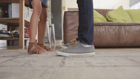 sección baja de padre e hija afroamericanos pies antes de bailar