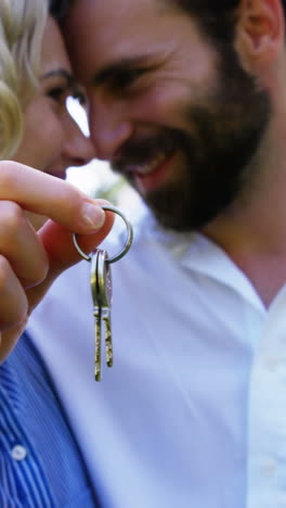 cute couple looking each other and holding keys