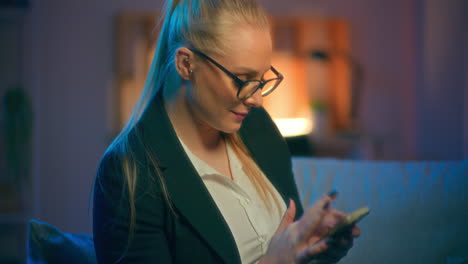 smiling woman browsing internet on smartphone and shopping online late in the evening