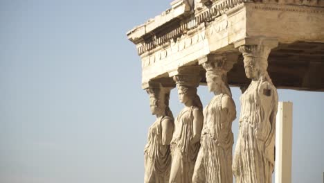 close view of the outer statues of cariátides and acropolis in athens greece