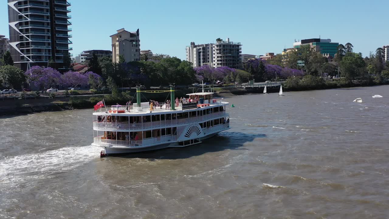 Drone shot flying through many small sailing boats having a sailing race on the Brisbane River, near West End and Toowong