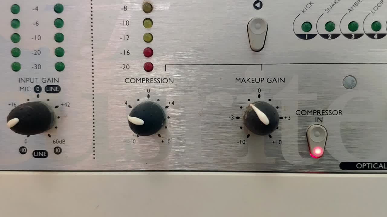 dispositivo de audio plateado con perillas y medidores de nivel led verticales.