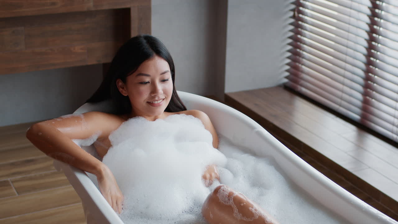 편안 한 거품 목욕 을 즐기는 여자