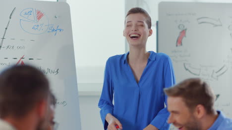 people laughing meeting room. happy woman pointing hand whiteboard in office