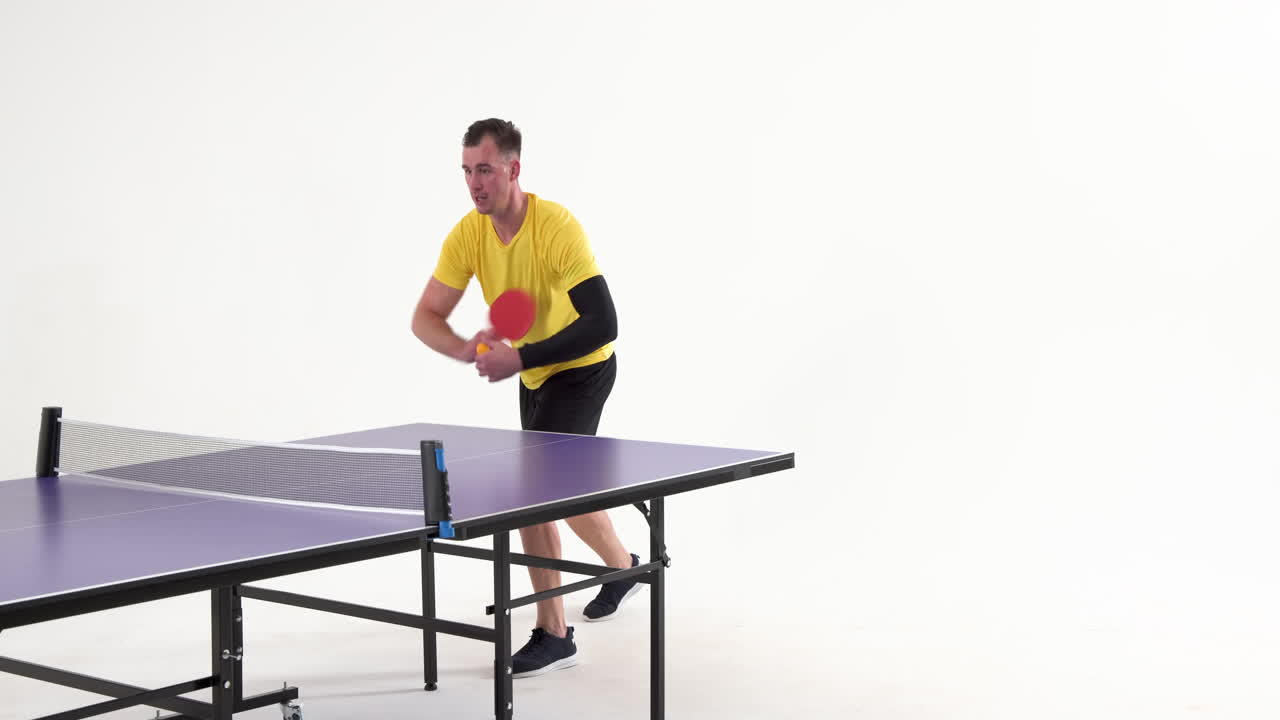 Male table tennis player serving and passing the ball on white background, copy space