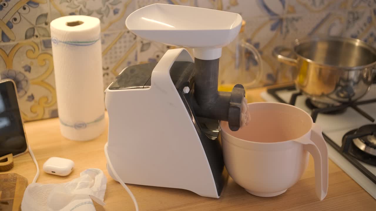 Electric Meat Grinder Mincing Raw Meat in a Home Kitchen