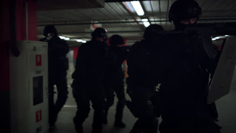 group of swat members walking on underground parking with weapons