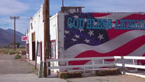 a roadside cafe along a remote highway and god bless america sign