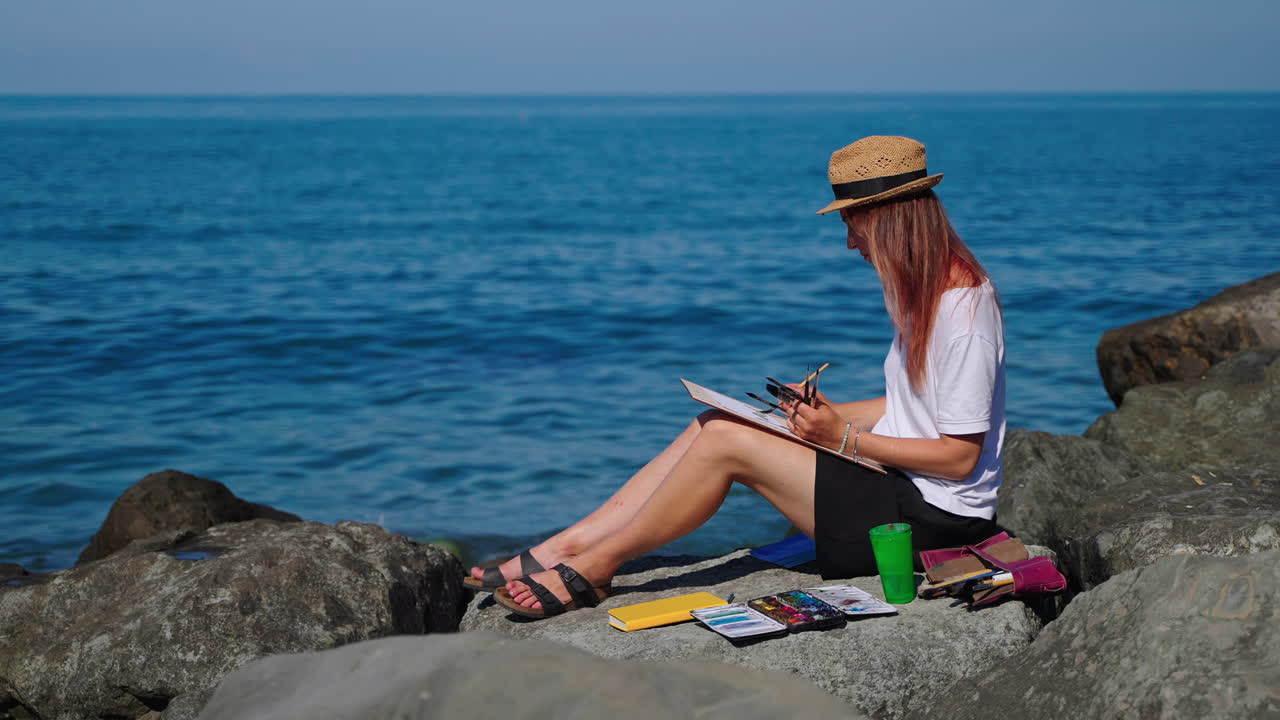 mujer pintando en la playa