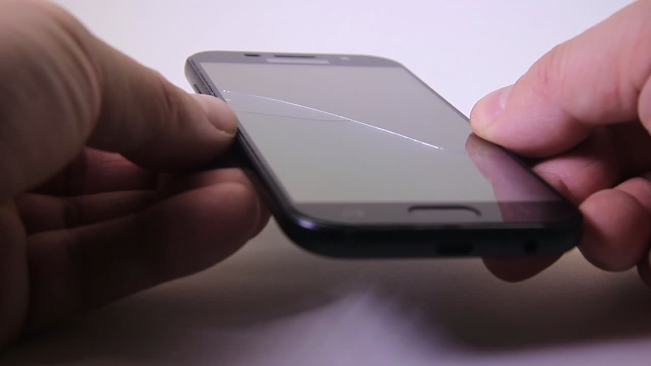 깨진 안전 유리-1이 있는 남성 검사 휴대전화 화면