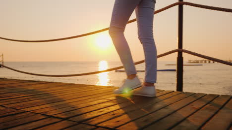 morning jog on the pier when the sun rises over the sea in the frame only the legs are visible stead