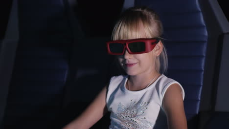 cool blonde girl is watching a movie in a 3d movie theater it blows the wind the seat rocks 4k video