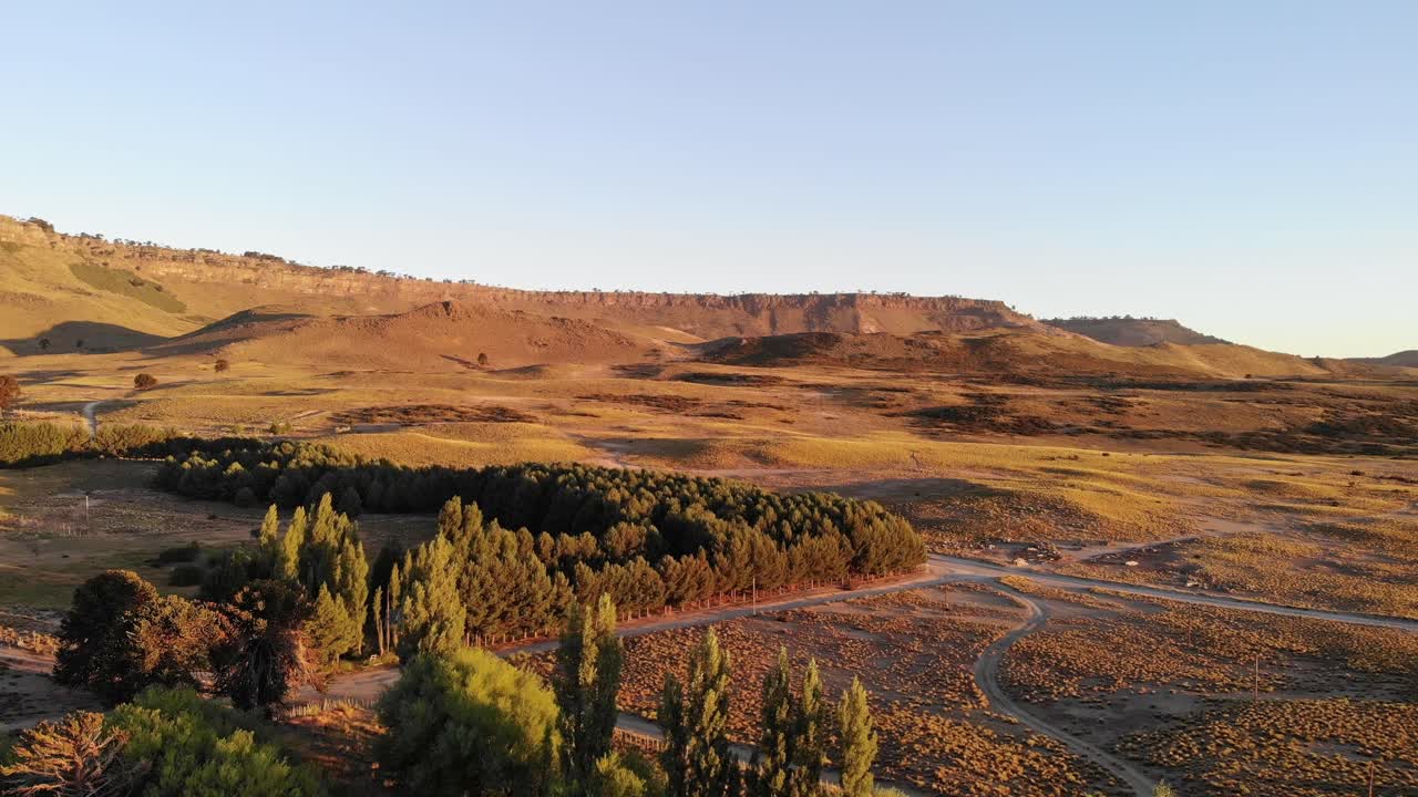 Scenic aerial of forests and mountains glowing in the warm light of sunset. Neuquen, Argentina