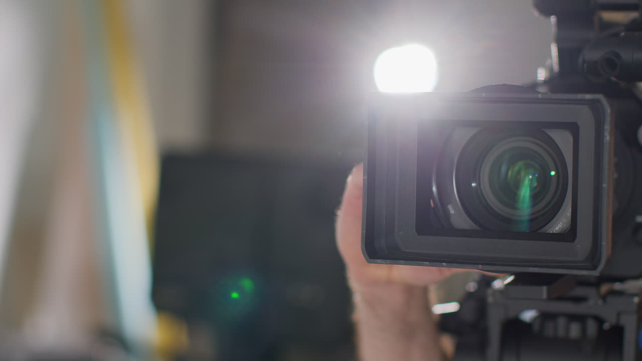 primer plano del operador de cámara de película masculino enfocando la lente en la cámara grabando una película o video en el estudio 2
