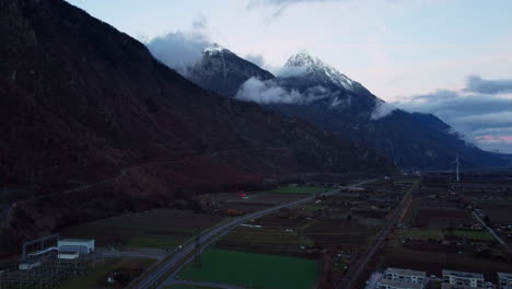 Vista-Aérea-Del-Valle-De-Martigny-En-Suiza---Hora-Azul-Sobre-La-Carretera-Entre-Montañas-Alpinas-En-El-Cantón-De-Valais