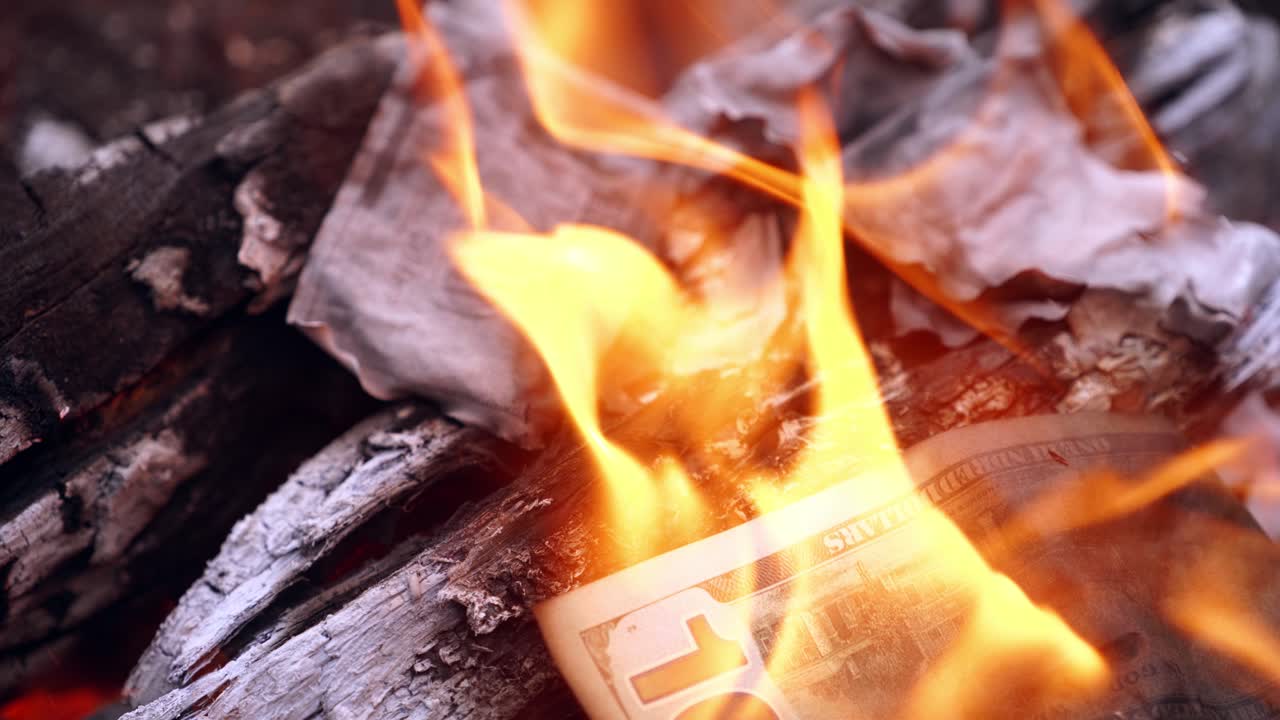 Close up of burning dollars. One hundred dollar bill on fire