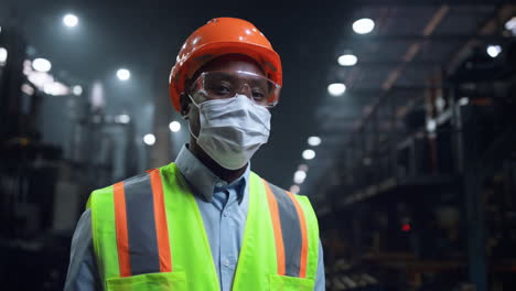 Mecánico-Con-Mascarilla-Mirando-La-Cámara-En-La-Fábrica-De-La-Empresa-De-Fabricación.