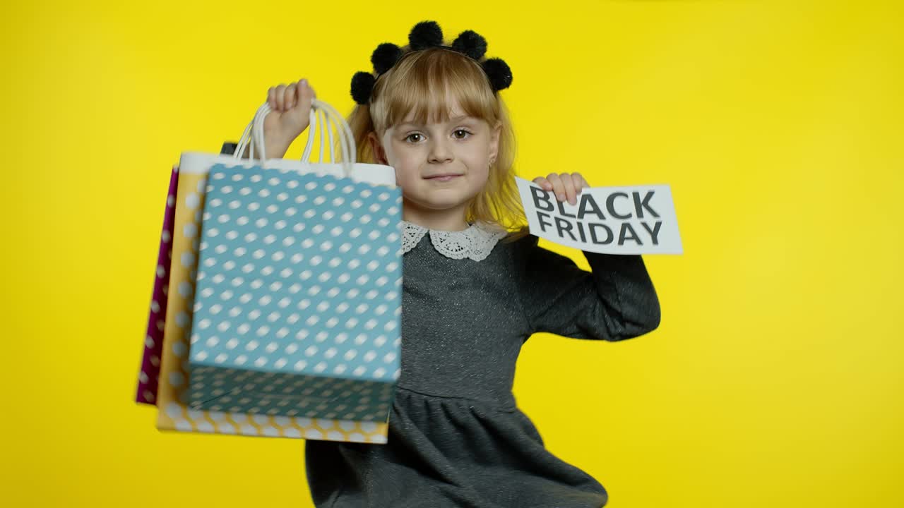 niña con bolsas de compras que muestran la inscripción de black friday, satisfecha con los bajos precios y descuentos