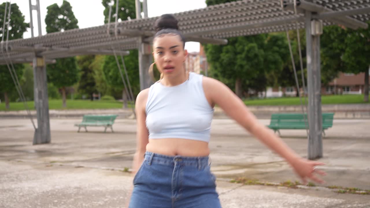 A young woman dancing in an urban park