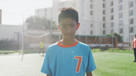 African-American-soccer-kid-in-blue-smiling-and-looking-at-camera