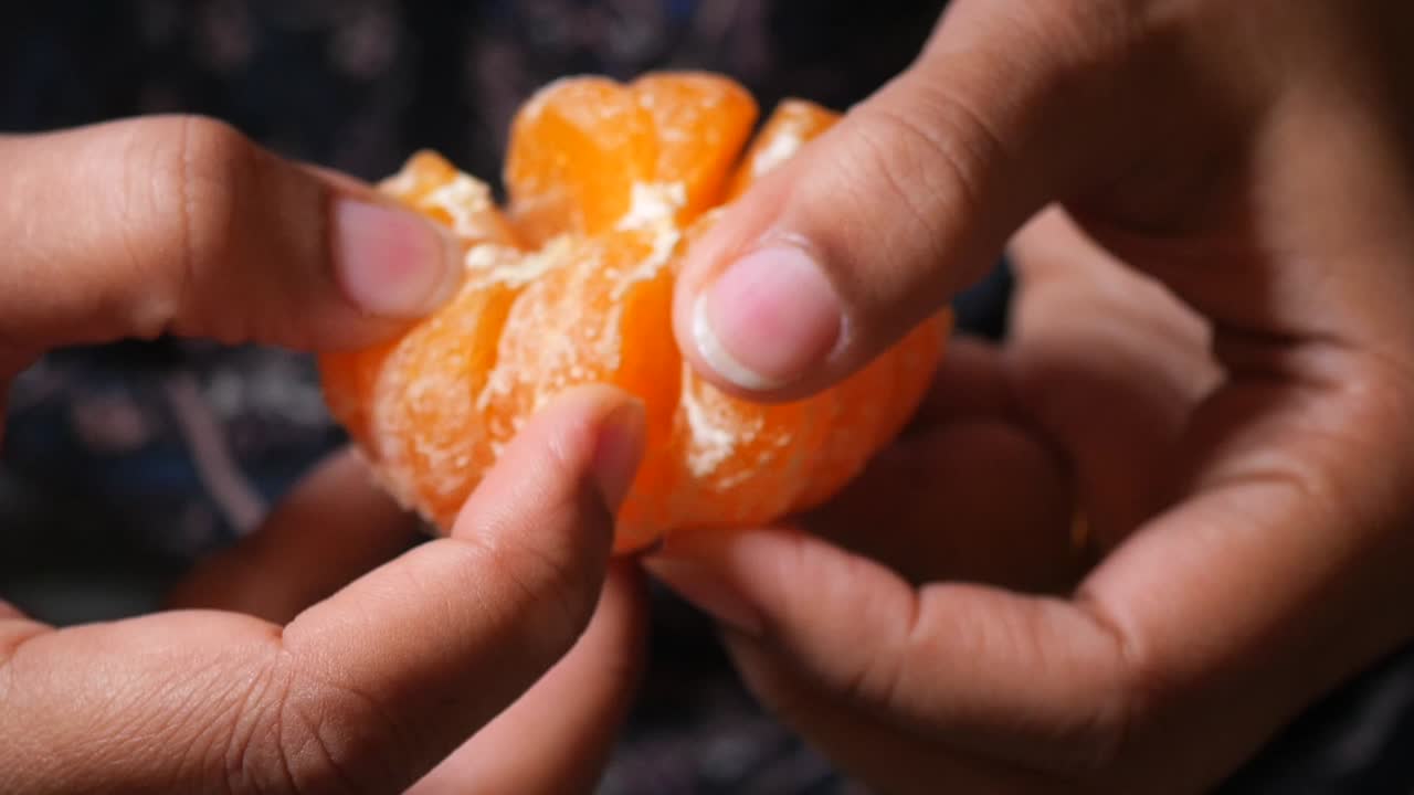 Close-up of Hands Peeling a Mandarin Orange