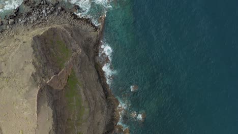 Drone-top-shot-of-waves-bounce-on-rocks-at-the-beach