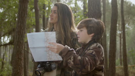 caucasian mother and son exploring wildlife in a natural park