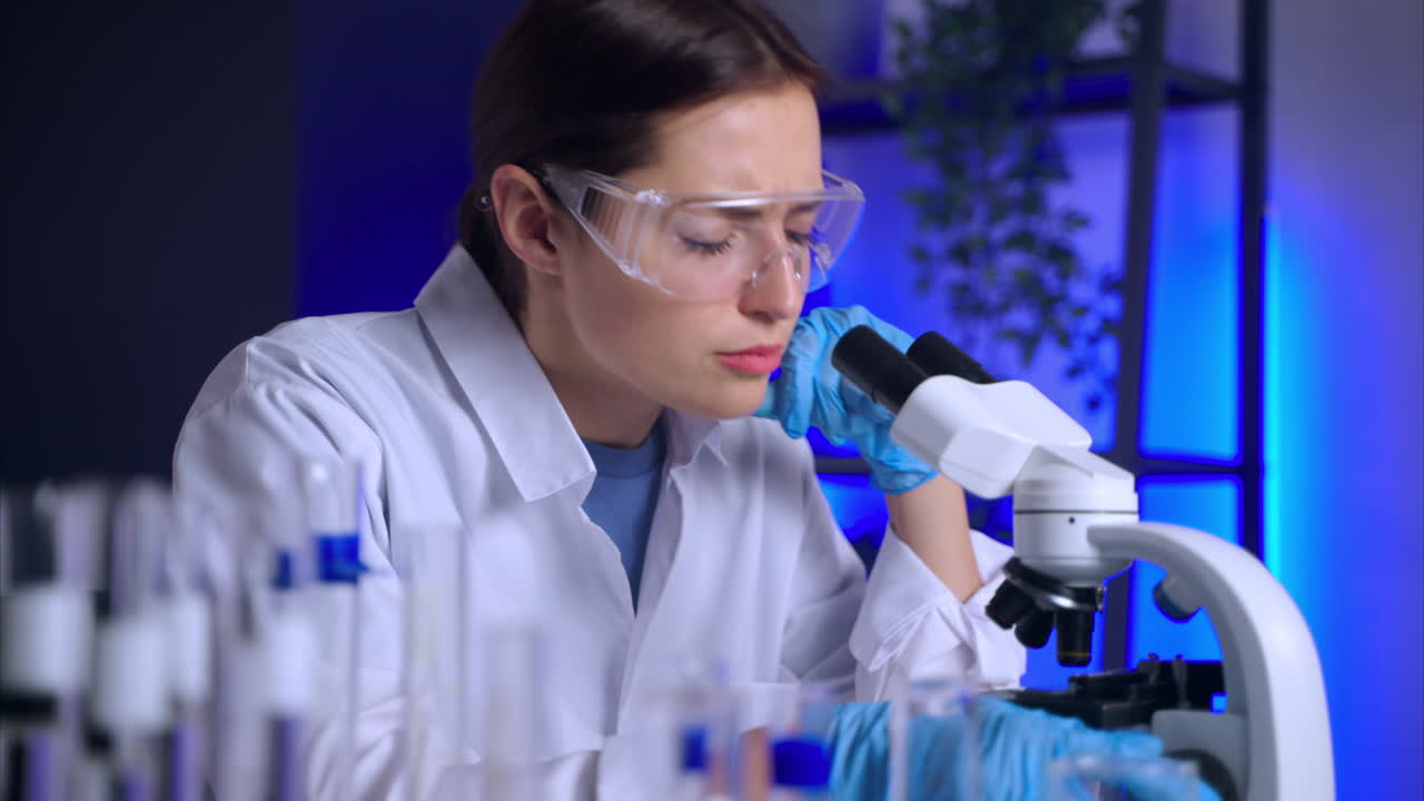 científico usando el microscopio en un entorno de laboratorio