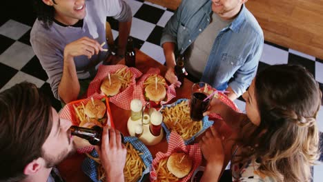 amigos comiendo hamburguesas y bebidas en un restaurante