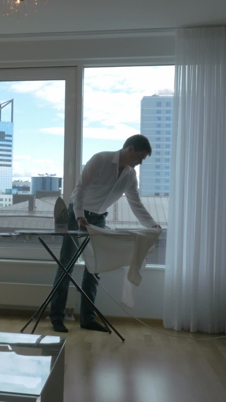 Man Ironing Clothes by Window