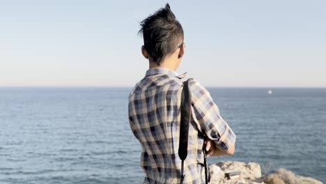 Dramatic-shot-behind-young-Nepali-man-looking-out-over-sea