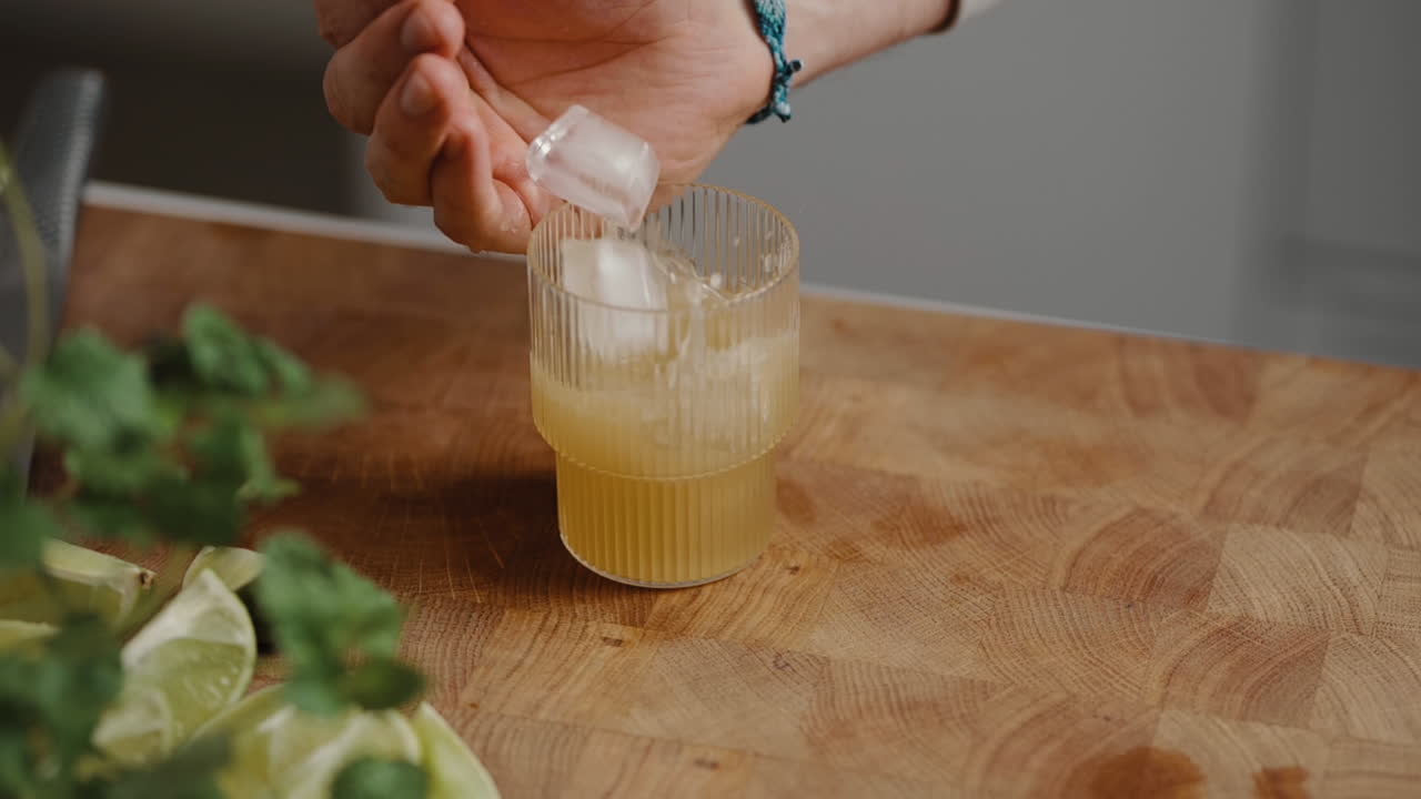 칵테일에 얼음 조각을 떨어뜨리는 젊은 남성