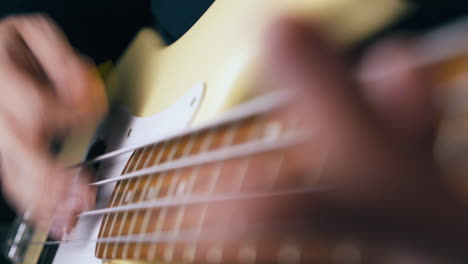 person plays bass guitar with yellow pick and sets pace