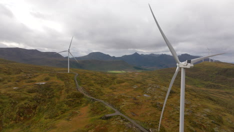 drone view of rotating wind turbines in alpine landscape of sortland, norway