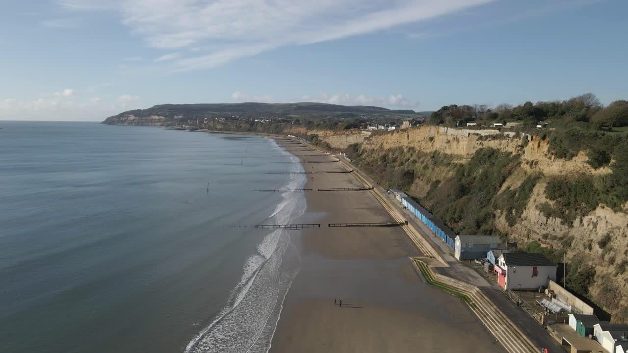 Aerial view of Sandown a seaside resort and civil parish on the south-east coast of the Isle of Wight, England. Drone moving forward over the beach heading on the left end of the sandown beach