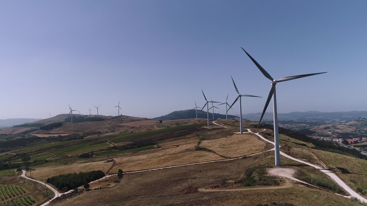 vista aérea hacia el parque de turbinas de molinos de viento en altas colinas, al oeste de portugal