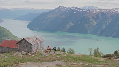 epic mountain biking adventure above the fjords near sogndal, norway. rider tackles rugged trails surrounded by dramatic cliffs, lush green hills, and stunning nordic scenery