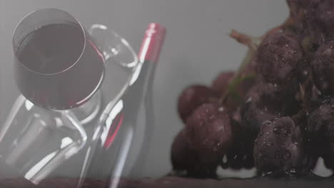 Compuesto-De-Vidrio-Y-Botella-De-Vino-Tinto-Sobre-Uvas-Y-Fondo-Gris