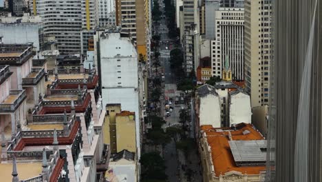 Inclinación-Aérea-Hacia-Arriba-Que-Revela-Una-Jungla-De-Piedra-Y-Una-Amplia-Avenida-En-La-Ciudad-De-Sao-Paulo,-Brasil