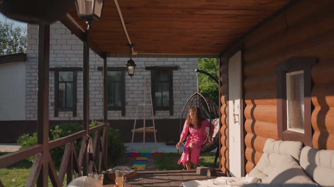 Woman Relaxes On Porch With Shadows, Individual Approaches Porch With Warm Sunlight And Peaceful Mood, Woman Steps Onto Porch Where Sunlight Creates Gentle Shadows And Tranquility Prevails